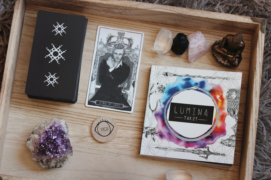 Tarot deck, guidebook, and crystals arranged on a wooden tray